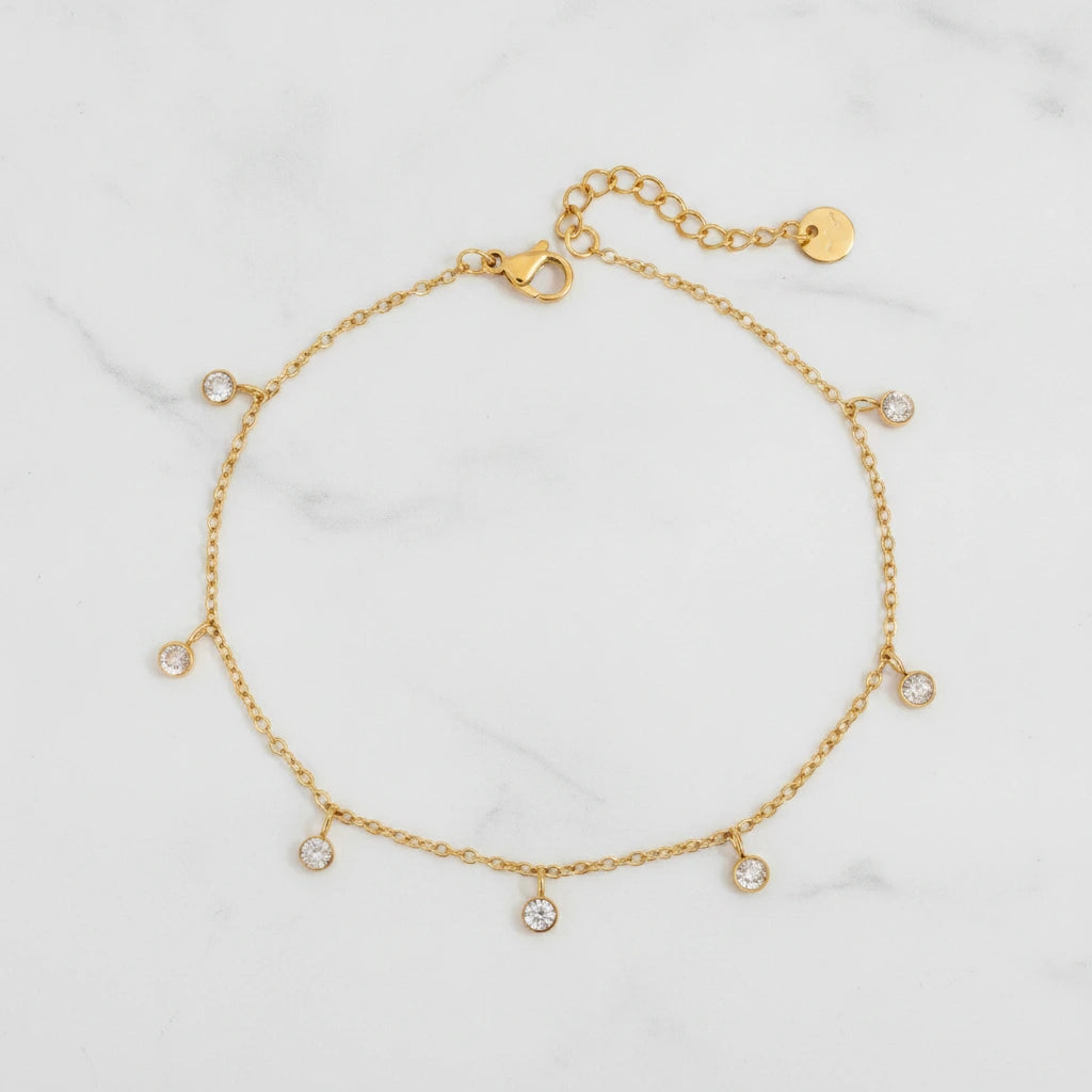 AURORA ANKLET | Place the original product large and centered on a clean white marble surface with a matching white marble background.