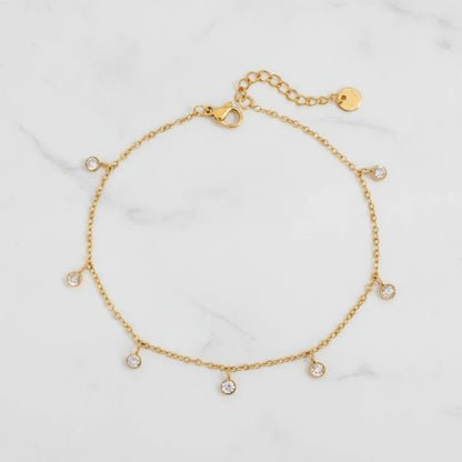 AURORA ANKLET | Place the original product large and centered on a clean white marble surface with a matching white marble background.
