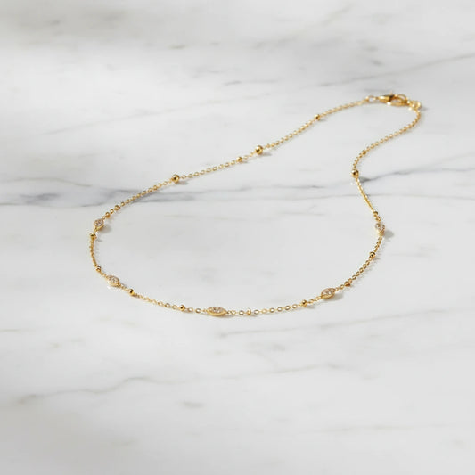BELLAGIO NECKLACE | Place the original product large and centered on a clean white marble surface with a matching white marble background.