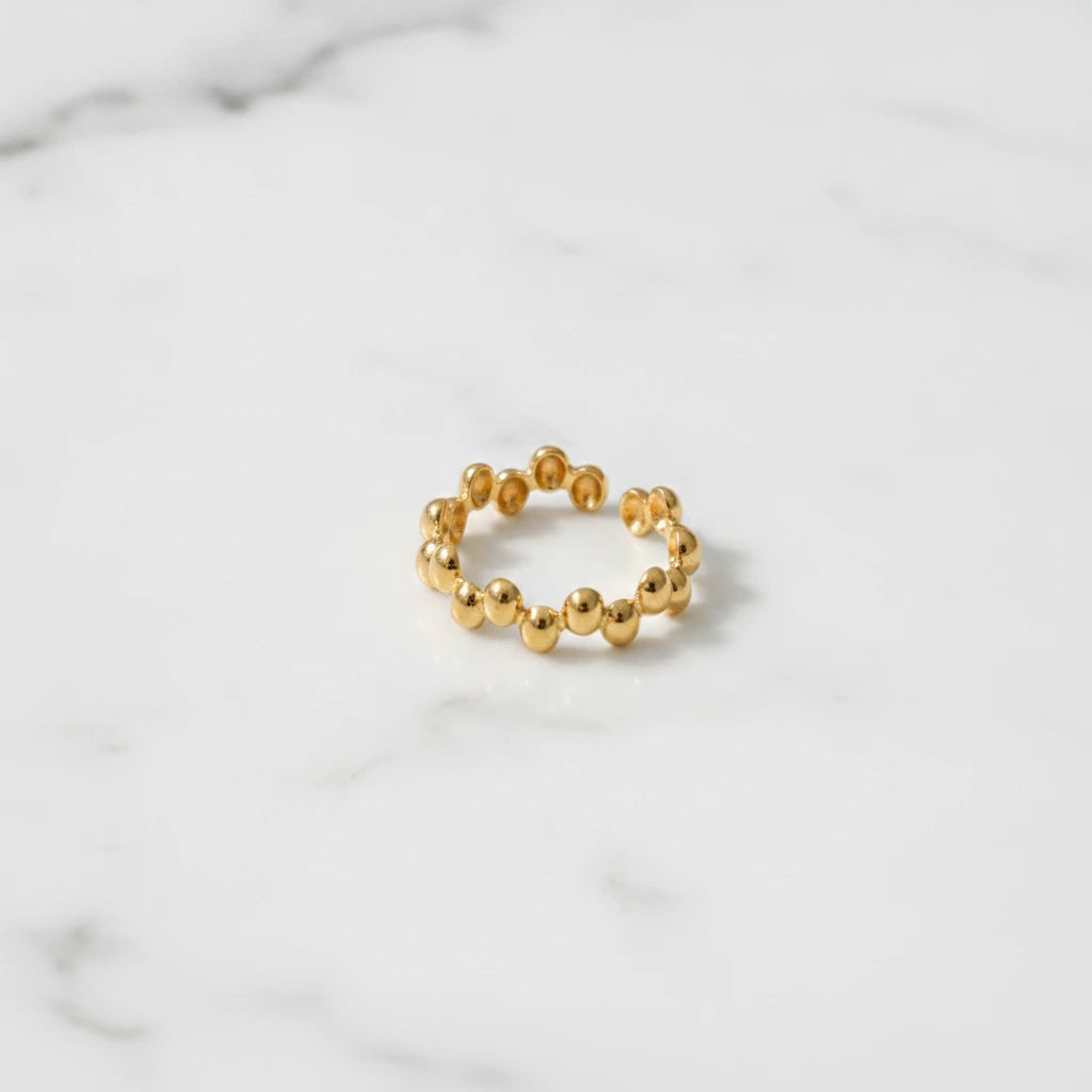 BUBBLE RINGS | Place the original product large and centered on a clean white marble surface with a matching white marble background.