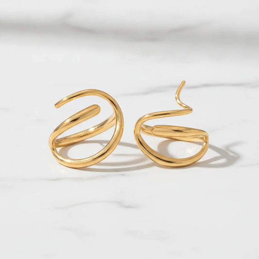 CAPI EARRINGS | Place the original product large and centered on a clean white marble surface with a matching white marble background.