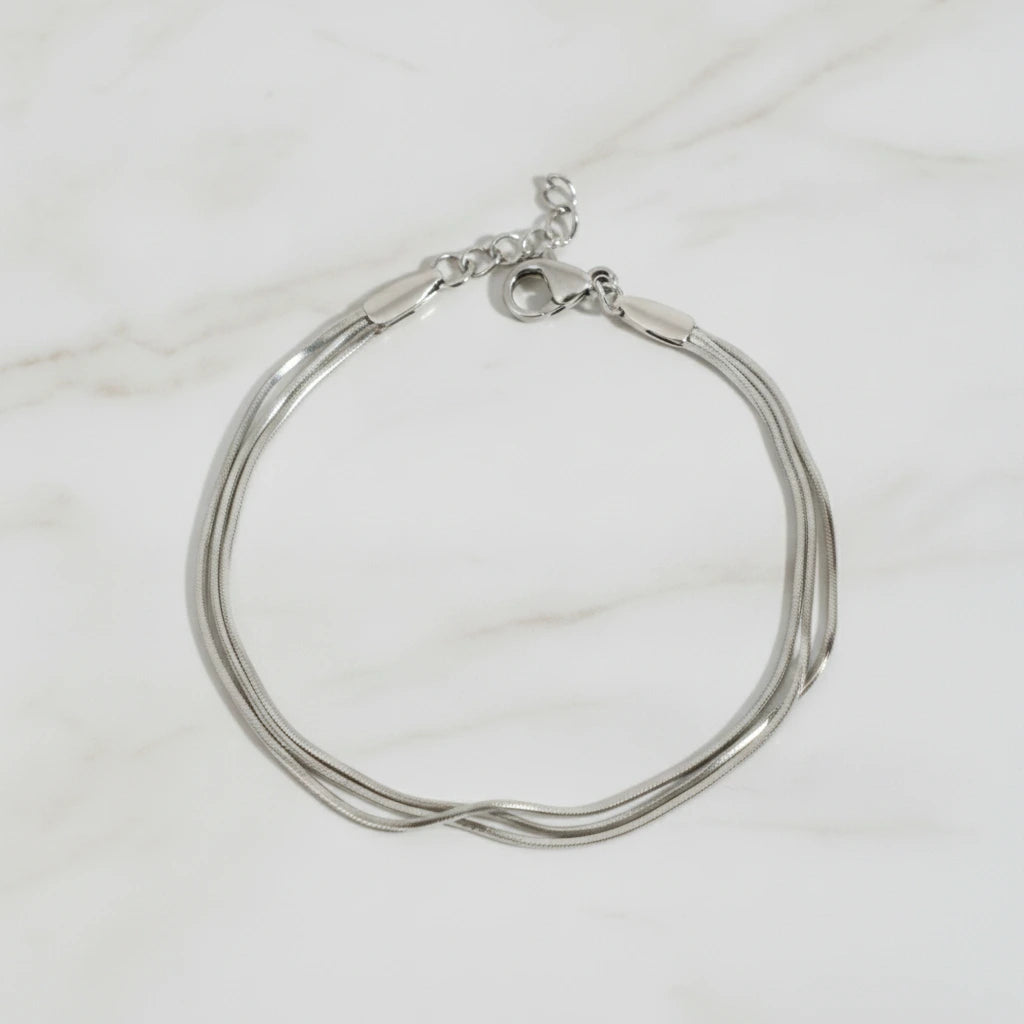 CLAIRE BRACELET | Place the original product large and centered on a clean white marble surface with a matching white marble background.