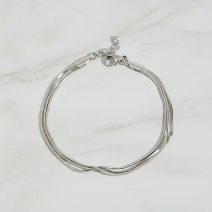 CLAIRE BRACELET | Place the original product large and centered on a clean white marble surface with a matching white marble background.