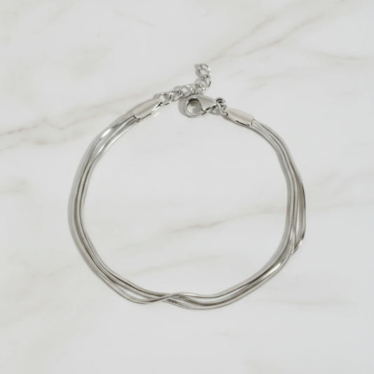 CLAIRE BRACELET | Place the original product large and centered on a clean white marble surface with a matching white marble background.