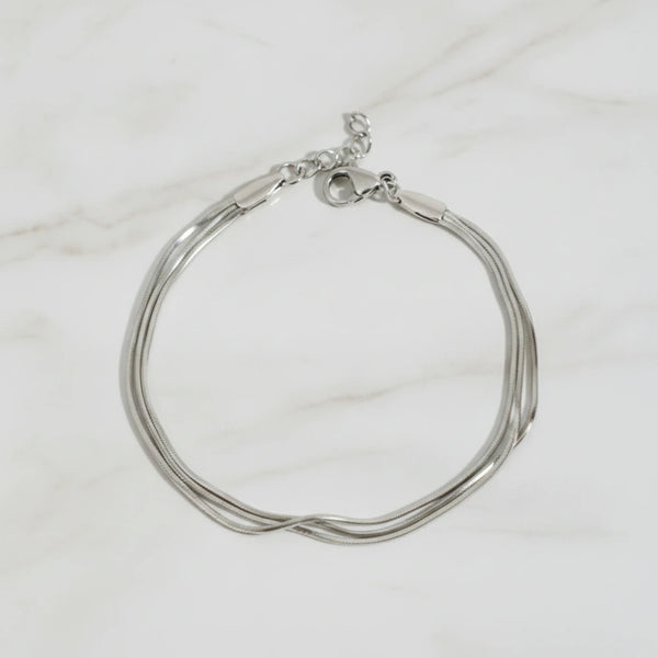 CLAIRE BRACELET | Place the original product large and centered on a clean white marble surface with a matching white marble background.