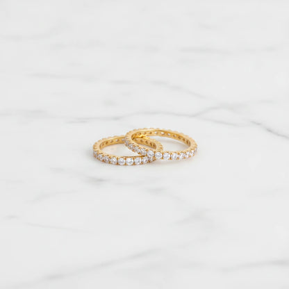 COMO RINGS | Place the original product large and centered on a clean white marble surface with a matching white marble background.