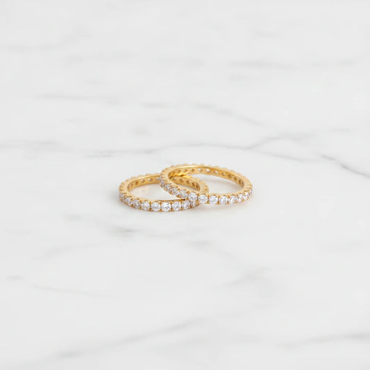 COMO RINGS | Place the original product large and centered on a clean white marble surface with a matching white marble background.
