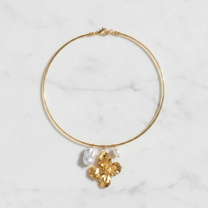 ELARA NECKLACE | Place the original product large and centered on a clean white marble surface with a matching white marble background.