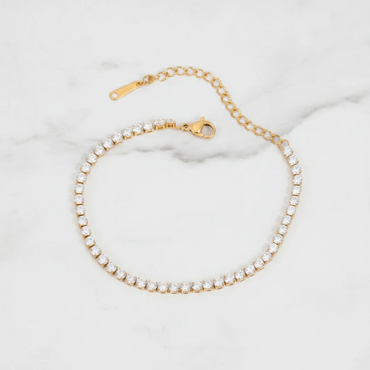 LUCIA BRACELET | Place the original product large and centered on a clean white marble surface with a matching white marble background.