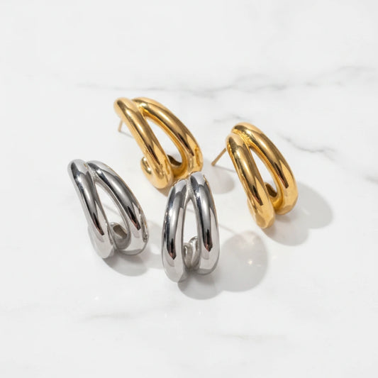 RAVELLO EARRINGS | Place the original product large and centered on a clean white marble surface with a matching white marble background.