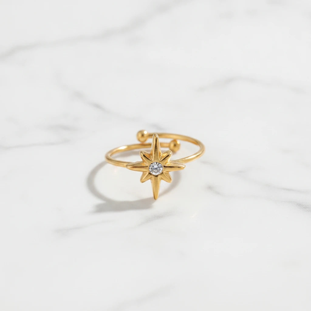 STAR RINGS | Place the original product large and centered on a clean white marble surface with a matching white marble background.