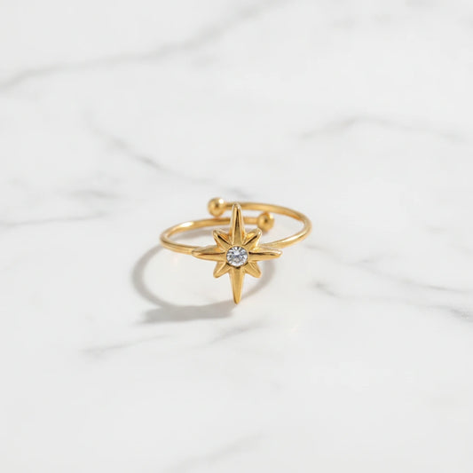 STAR RINGS | Place the original product large and centered on a clean white marble surface with a matching white marble background.